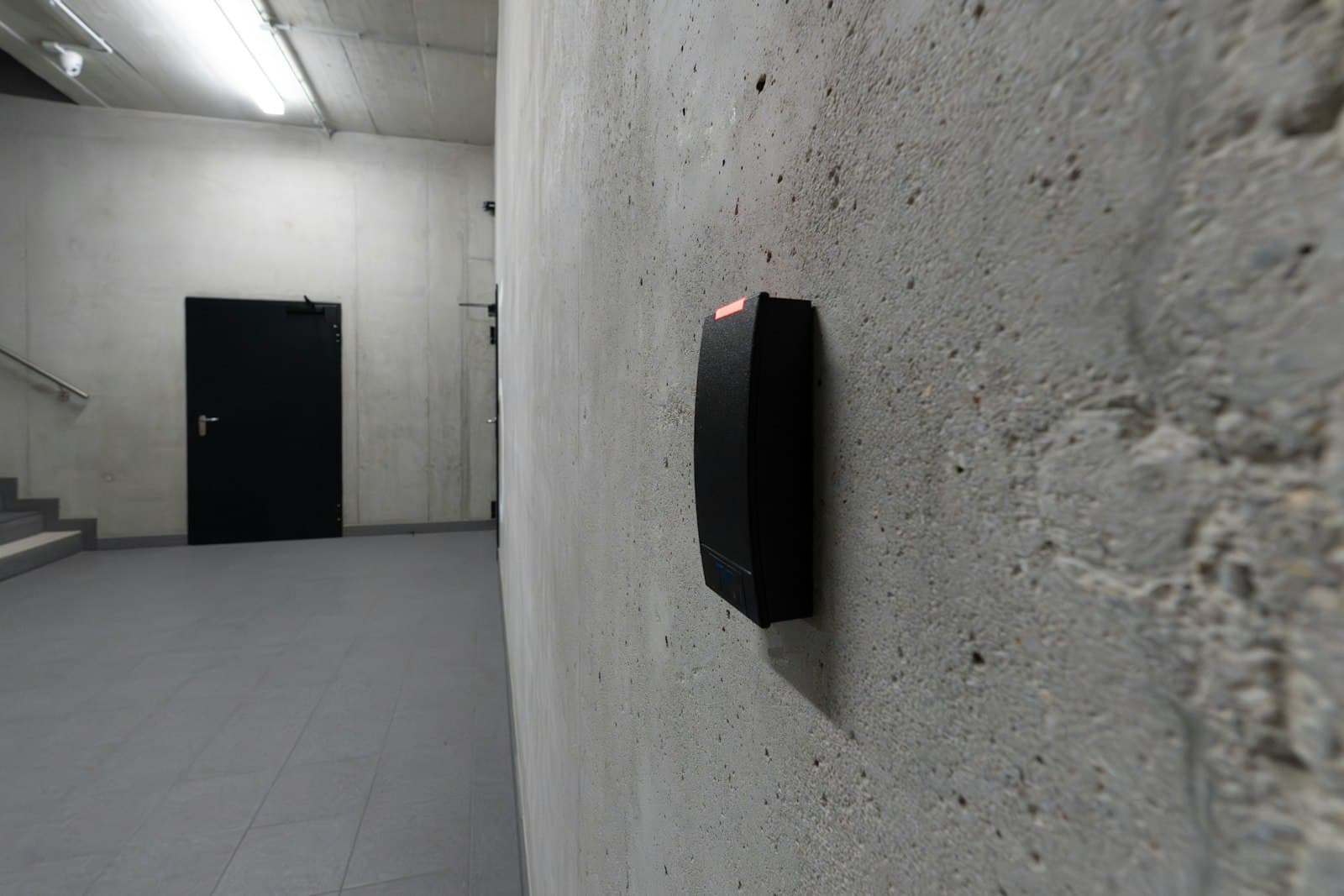 Lecteur de badge RFID installé sur un mur en béton à l'entrée d'un bâtiment